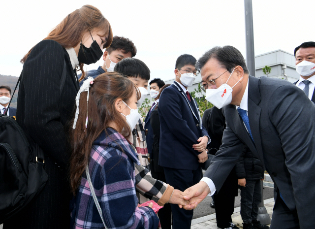 문재인 대통령이 6일 오전 충남 공주시 중앙소방학교 화재진압훈련장에서 열린 제58주년 소방의 날 기념식에서 독도 헬기 추락사고로 순직한 고(故) 서정용 정비사 유가족을 위로하고 있다. 문 대통령은 이날 기념사 도중 인명 구조 도중 순직한 소방관들의 이름을 일일이 호명하며 소방관들의 희생과 헌신을 기렸다./연합뉴스