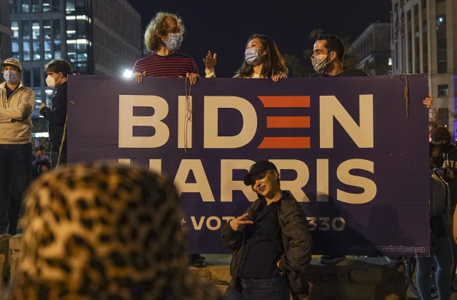 7일 미국 워싱턴DC의 조 바이든 당선인의 선거 플래카드 앞에서 지지자들이 기념사진을 찍고 있다. /UPI연합뉴스