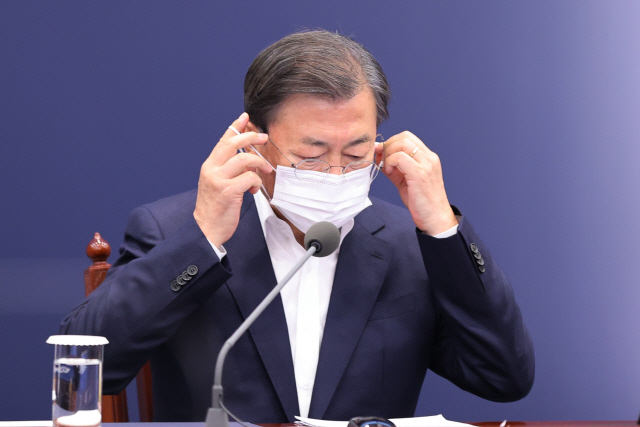 문재인 대통령이 9일 청와대에서 열린 수석·보좌관 회의에서 발언에 앞서 마스크를 벗고 있다./연합뉴스
