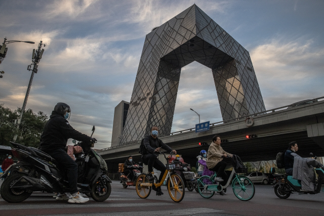 지난달 28일 중국 베이징 차오양구의 중국중앙(CC)TV 본사 앞을 자전거와 오토바이가 지나가고 있다. /EPA연합뉴스