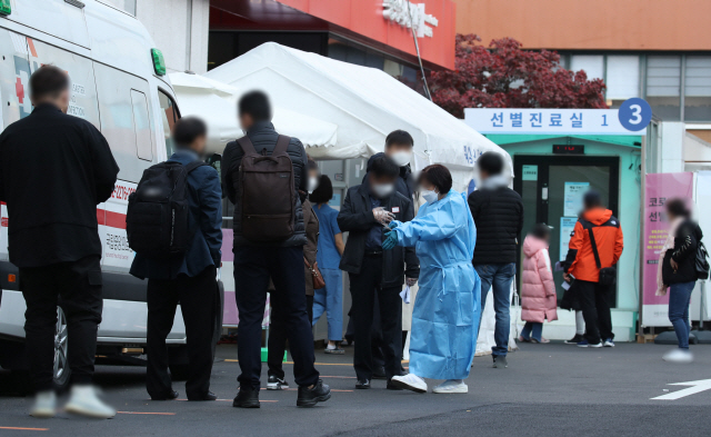 11일 오전 서울 중구 국립중앙의료원 선별진료소에서 시민들이 코로나19 검사를 받기 위해 줄을 서 있다. /연합뉴스