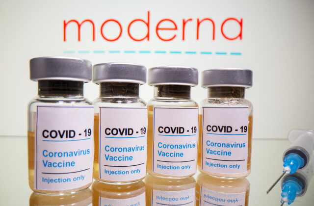 Vials with a sticker reading, “COVID-19 / Coronavirus vaccine / Injection only” and a medical syringe are seen in front of a displayed Moderna logo in this illustration taken October 31, 2020. REUTERS/Dado Ruvic/Illustration        <저작권자(c) 연합뉴스, 무단 전재-재배포 금지>