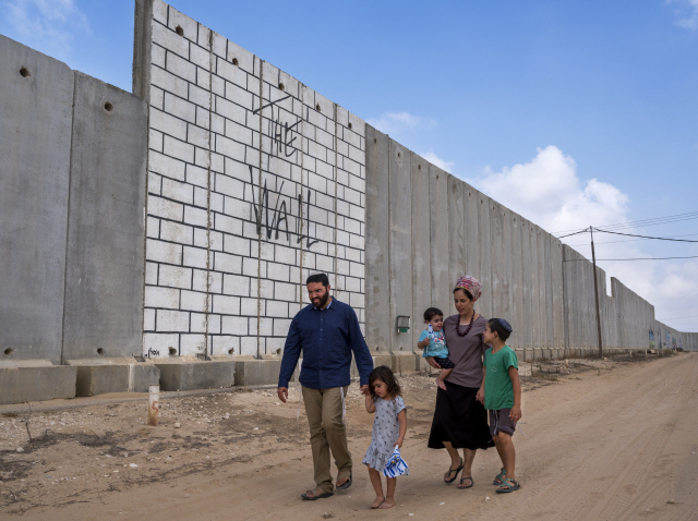 2018년 8월 이스라엘 정부가 설치한 가자 지구 분리 장벽 앞으로 한 가족이 걸어가고 있다./EPA연합뉴스