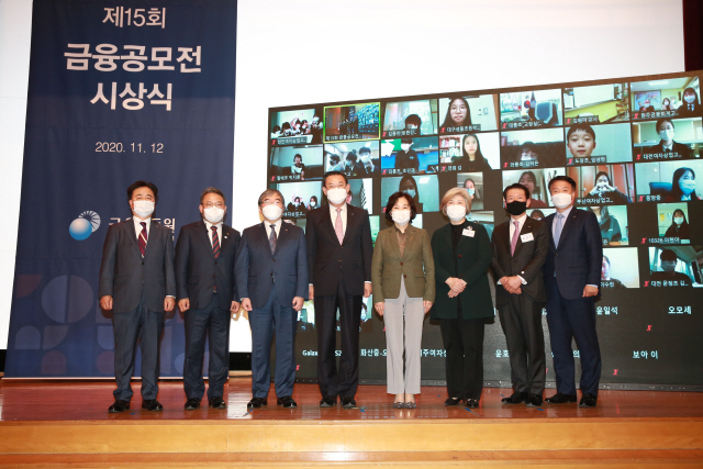 윤석헌(왼쪽 세번째부터) 금융감독원장, 김태영 은행연합회장, 김은경 금감원 소보처장이 12일 서울 여의도 금감원 강당에서 열린 제15회 금융공모전 시상식에서 수상자들을 축하하고 있다. 이날 수상자 중 일부는 온라인 화상으로 참석했다./사진제공=금융감독원