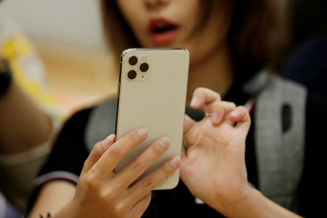 중국 베이징의 한 애플 매장을 찾은 고객이 아이폰을 살펴보고 있다. /로이터연합뉴스