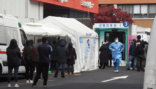 15일 오전 서울 중구 국립중앙의료원 선별진료소에서 시민들이 코로나19 검사를 받기 위해 길게 줄지어 차례를 기다리고 있다. /오승현기자