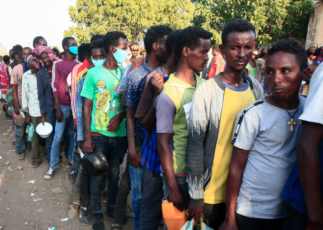 분쟁지역인 에티오피아 티그라이에서 탈출한 이주민들이 14일(현지시간) 식량 배급을 타기 위해 줄을 서 있다. /AFP연합뉴스