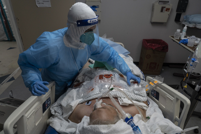 미국 텍사스즈 휴스턴의 유나이티드 메모리얼 메디컬 센터의 의료진이 14일(현지시간) 코로나19로 중환자실에 입원한 환자를 돌보고 있다./AFP연합뉴스