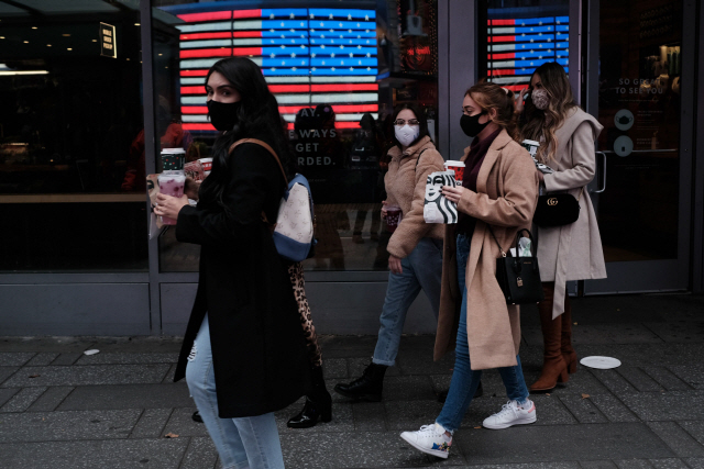 15일 마스크를 쓴 사람들이 뉴욕 맨해튼의 타임스 스퀘어 앞을 걷고 있다. /AFP연합뉴스