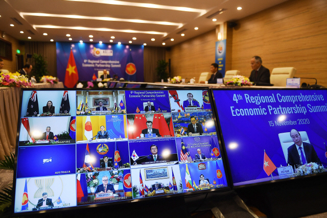 아세안 의장국인 베트남의 수도 하노이에서 15일(현지시간) 화상으로 열린 ‘역내포괄적경제동반자협정(RCEP)’ 정상회의 및 서명식에서 응우옌쑤언푹(화면 오른쪽) 베트남 총리가 연설하고 있다. /AFP연합뉴스