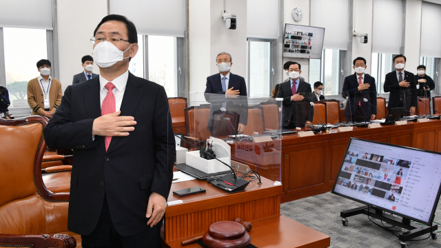 17일 오전 서울 여의도 국회에서 열린 국민의힘 화상 의원총회에서 김종인 비대위원장과 주호영 원내대표 등 참석자들이 국기에 대한 경례를 하고 있다. /연합뉴스