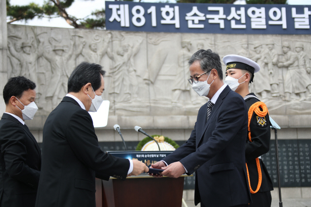 정세균(왼쪽) 국무총리가 17일 서울 서대문독립공원 순국선열추념탑에서 열린 ‘제81회 순국선열의 날 기념식’에 참석해 독립유공자에게 포상하고 있다.        /연합뉴스