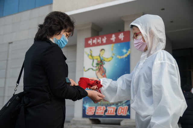 지난 16일 북한의 어머니날을 맞아 북한 평양의 한 극장에서 진행된 국립교예단의 공연을 관람하려는 관람객이 코로나19 방역을 위해 검역관의 체온 측정에 응하고 있다. 유엔 제3위원회는 18일(현지시간) 북한의 인권침해를 비판하고 개선을 촉구하는 북한인권결의안을 16년 연속 통과시켰다. /AFP연합뉴스