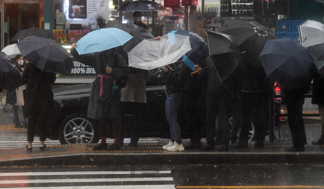 강풍을 동반한 요란한 가을비가 내린 19일 오전 우산을 쓴 시민들이 서울 서대문역 인근에서 비바람을 맞으며 출근길 발걸음을 재촉하고 있다. 기상청은 비가 그친 뒤 북쪽에서 찬 공기가 내려와 기온이 큰 폭으로 떨어질 것이라며, 오는 21일 아침에는 대부분 지역에서 영하권 추위를 보일 것이라 내다봤다./오승현기자 2020.11.19