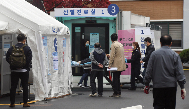 18일 오전 서울 중구 국립중앙의료원 선별진료소를 찾은 시민들이 코로나19 검사를 받고 있다./오승현 기자