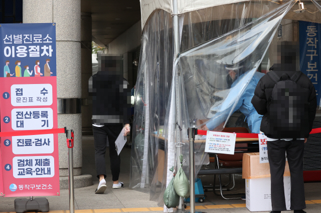 중등 임용고시 시험을 하루 앞둔 20일 서울 동작구 노량진의 한 대형 임용고시 학원에서 신종 코로나바이러스 감염증(코로나19) 확진자가 다수 발생한 가운데 이날 오후 동작구보건소에서 학원생들이 검사를 받기 위해 선별진료소로 들어서고 있다./연합뉴스