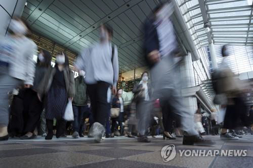 20일 도쿄의 한 역에서 직장인들이 마스크를 쓰고 이동하고 있다./연합뉴스