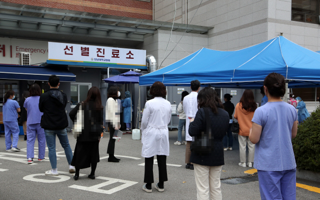 20일 오후 광주 동구 전남대학교병원에서 병원 의료진과 직원들이 코로나19 검사를 받기 위해 선별진료소 앞에 서서 기다리고 있다. /연합뉴스