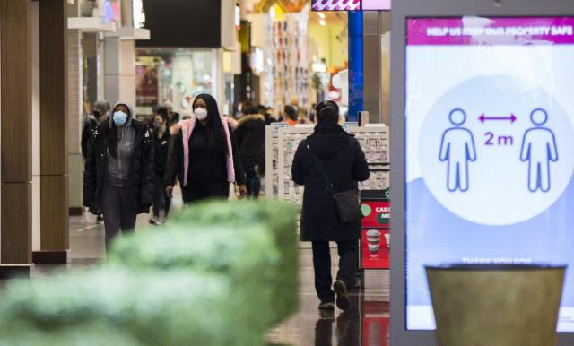 지난 18일 캐나다 온타리오주의 한 쇼핑몰을 방문한 사람들이 마스크를 쓰고 걸어가고 있다. 온타리오 주정부는 이날 코로나19 재확산에 따라 식당 등의 영업을 일부 제한하기로 결정했다. /신화연합뉴스