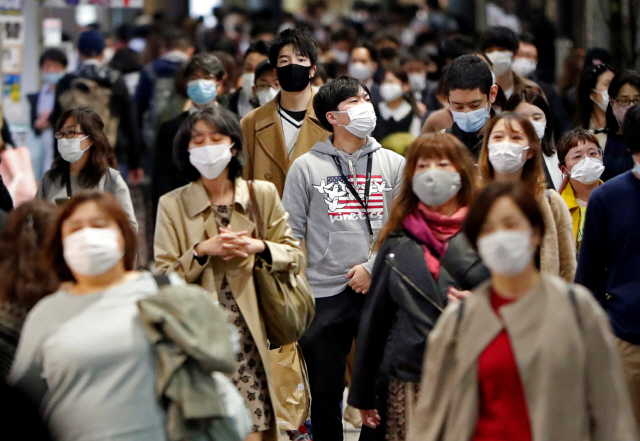 지난 19일 일본 도쿄에서 마스크를 쓴 시민들이 걸어가고 있다. /로이터연합뉴스