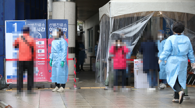 동작구 노량진 임용고시학원 관련 추가 감염자가 속출하는 등 국내 신종 코로나바이러스 감염증(코로나19) 확산세가 꺾이지 않는 22일 오전 서울 동작구보건소에 차려진 선별진료소에서 시민들이 검사를 받기 위해 기다리고 있다. /연합뉴스