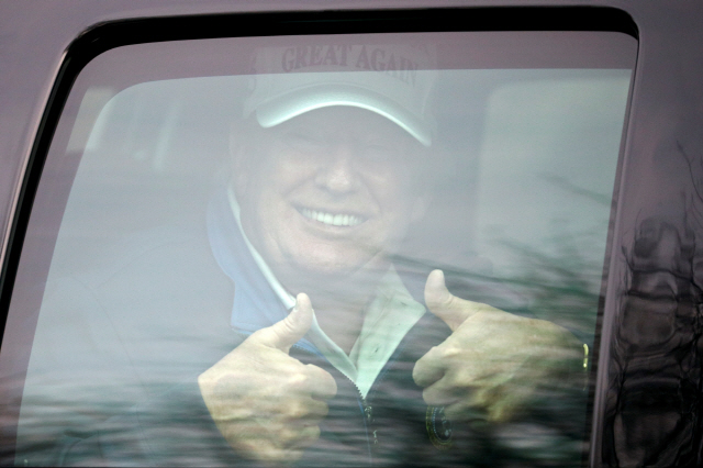 도널드 트럼프 미국 대통령이 22일(현지시간) 버지니아주 스털링의 트럼프내셔널골프클럽을 떠나면서 차 안에서 지지자들을 향해 엄지손가락을 세워 보이고 있다. /로이터연합뉴스