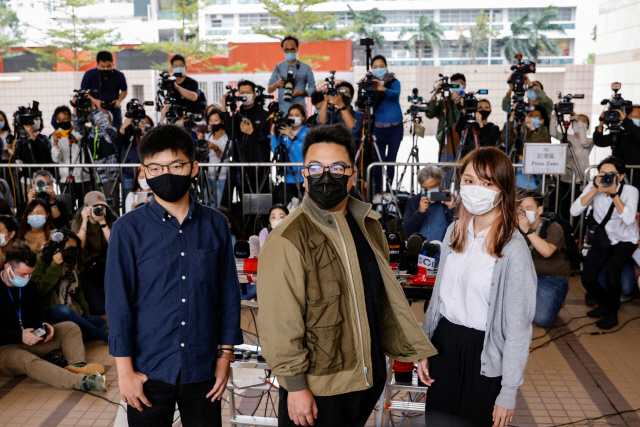 23일(현지시간) 재판을 받기 위해 웨스트카오룽 치안법원에 도착한 홍콩 민주화 운동가 조슈아 웡(왼쪽부터)과 이반 램, 아그네스 차우. 이들은 지난해 벌어진 대규모 불법집회 가담 혐의 등으로 이날 구류 처분을 받고 수감됐다./로이터연합뉴스