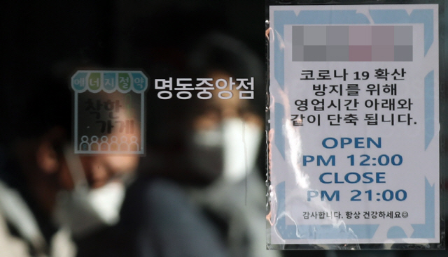 23일 서울 명동의 한 가게에 영업시간 단축 관련 안내문이 붙어 있다. /연합뉴스