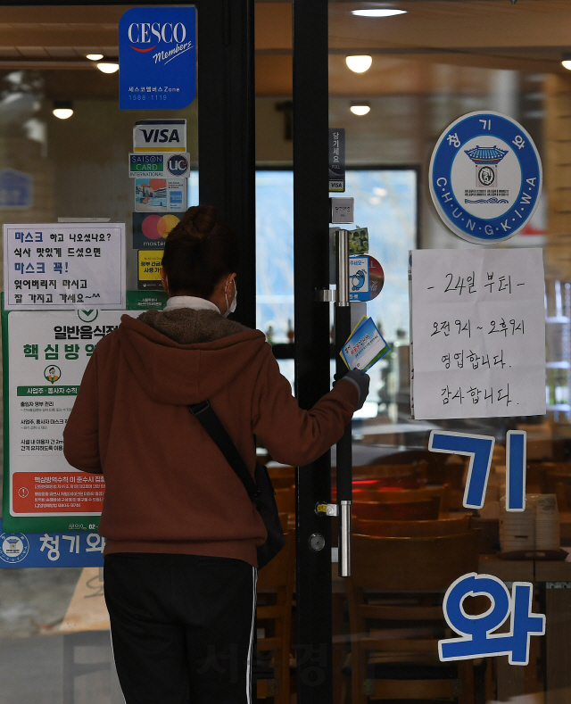 코로나19 확산으로 수도권의 사회적 거리두기 2단계 격상 및 서울시의 '1천만 시민 멈춤기간' 첫날인 24일 서울 마포구 홍대거리의 한 24시간 음식점 입구에 2단계 격상으로 인한 영업시간 변경 안내문이 붙어 있다./오승현기자 2020.11.24