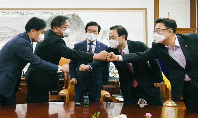 23일 국회 의장실에서 박병석 국회의장 주재로 열린 ‘공수처법 해법’ 논의 여야 원내대표 회동에서 참석자들이 주먹인사하고 있다. 왼쪽부터 김영진 더불어민주당 원내수석부대표, 김태년 원내대표, 박병석 국회의장,  주호영 국민의힘 원내대표, 김성원 원내수석부대표. /연합뉴스