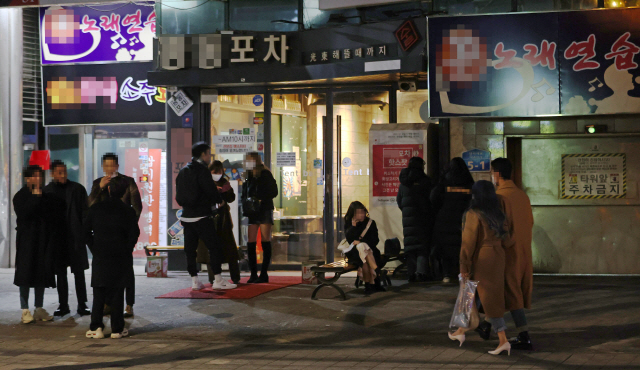 24일 자정 홍익대학교 인근 주점을 찾은 시민들이 주점 영업이 종료되자 거리를 서성이고 있다./연합뉴스