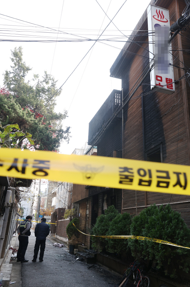 25일 오전 2시 39분께 서울 마포구 공덕동의 한 모텔에서 방화로 인한 화재가 발생해 2명이 숨졌고, 9명이 부상을 입었다. 이날 오전 화재가 발생했던 모텔 주위에 폴리스라인이 설치돼돼 있다./연합뉴스