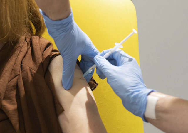 옥스퍼드대와 아스트라제네카가 공동 개발 중인 코로나19 백신을 한 임상 시험 참가자가 투약 받고 있다./AP연합뉴스