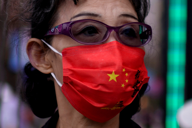 중국 상하이의 한 여성이 중국 국기가 그려진 마스크를 쓰고 쇼핑가를 걷고 있다. /로이터연합뉴스