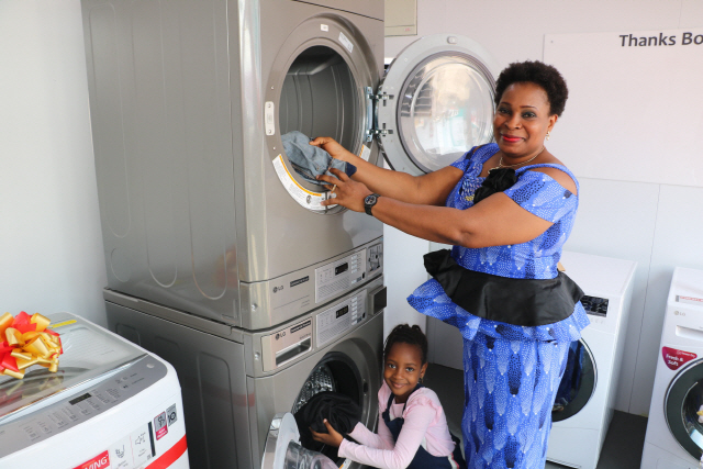 나이지리아 베닌시 주민들이 무료세탁방 ‘라이프스 굿 위드 LG 워시’를 방문해 건조기에 빨래를 넣고 있다./사진제공=LG전자