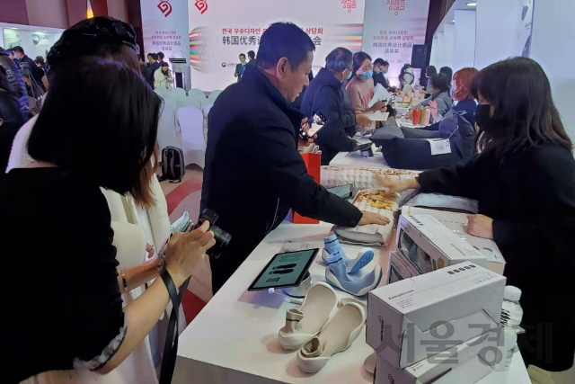 26일 베이징에서 열린 ‘한국 우수디자인 프리미엄 소비재 상담회’에 소개된 ‘포켓슈즈’를 중국 바이어들이 살펴보고 있다.