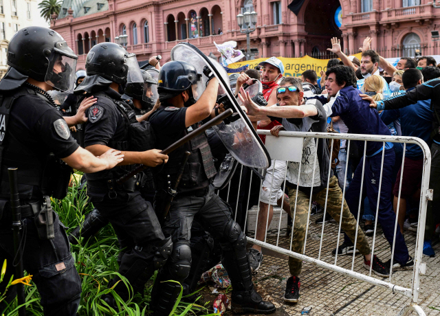 지난 26일(현지시간) 마라도나의 빈소가 마련된 아르헨티나 수도 부에노스아이레스의 대통령궁 카사 로사다에 들어가려던 팬들이 통제에 나선 경찰과 충돌하고 있다./연합뉴스