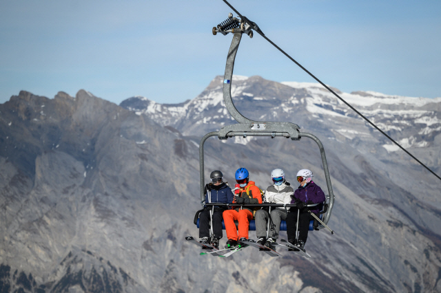 지난 15일 스위스 알프스의 부비에르 스키장 상공에서 이용객들이 스키 리프트 이용하는 모습/연합뉴스