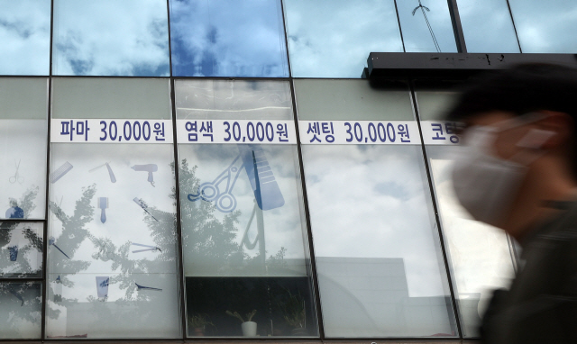 서울의 한 미용실 앞을 시민이 마스크를 쓴 채 지나가고 있다. /연합뉴스