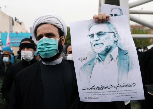 이란의 핵 개발을 이끌었던 과학자 모센 파크리자데가 테러로 사망한 다음날인 28일(현지시간) 이란 수도 테헤란에서 테러에 반발하는 시위자들이 파크리자데의 얼굴이 담긴 그림을 들고 시위하고 있다./로이터연합뉴스