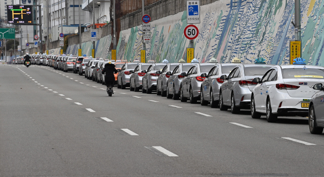코로나19 3차 대유행이 진행 중인 29일 오후 서울역 인근에서 택시들이 줄지어 승객을 기다리고 있다. 코로나19 확산으로 올해 1∼8월기간 동안 지난해보다 1.82배 늘어난 전국 택시 1만2,000여 대가 휴업을 신고하고 운행을 멈췄다./오승현기자 2020.11.29