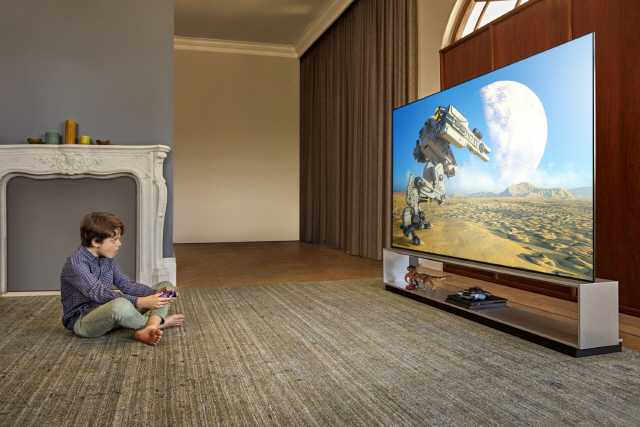 LG전자 모델이 LG 올레드 TV를 활용해 게임을 즐기고 있다. /사진제공=LG전자