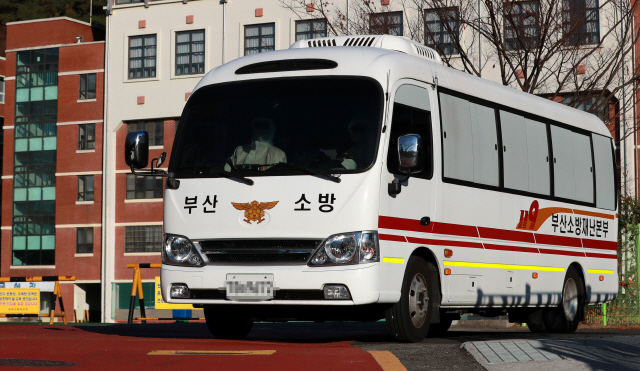 30일 오후 부산 한 고등학교에서 코로나19 확진자 20여명이 대구 동산병원으로 이송되고 있다./연합뉴스