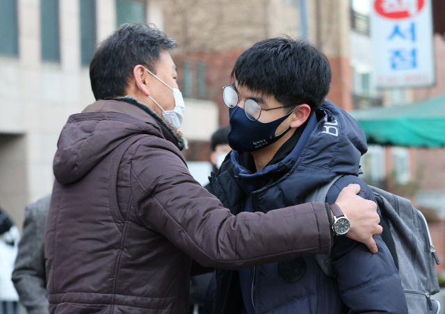 대학수학능력시험일인 3일 오전 서울 종로구 경복고에서 한 학부모가 고사장으로 들어가는 자녀를 격려하고 있다./연합뉴스