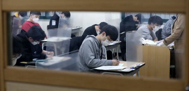 2021학년도 대학수학능력시험이 치러진 3일 오전 서울 종로구 경복고등학교에 고사장에서 수험생들이 시험지를 받고 답안지에 마킹하고 있다. /사진공동취재단