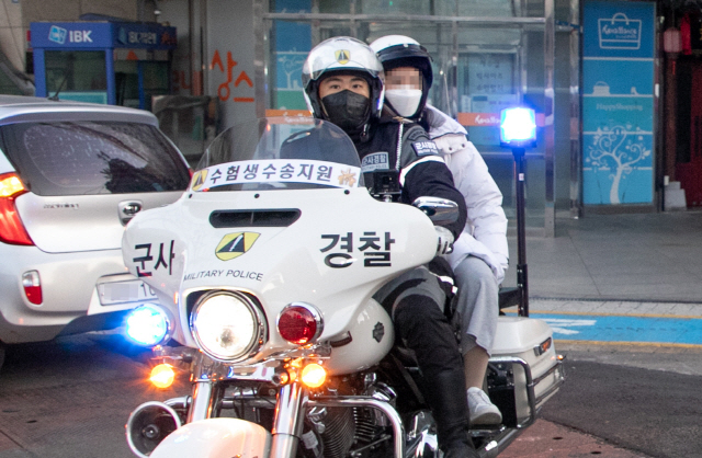 대학수학능력시험일인 3일 서울 신림역 인근에서 육군 수도방위사령부 군사경찰단이 오토바이로 수험생을 고사장으로 데려다주고 있다./연합뉴스