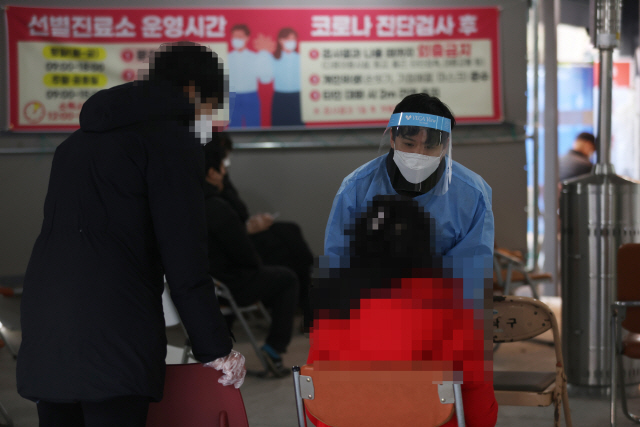 6일 오후 서울 동작구 보건소에 마련된 선별진료소에서 의료진이 신종 코로나바이러스 감염증(코로나19) 검사를 받으러 온 시민의 상태를 확인하고 있다. /연합뉴스