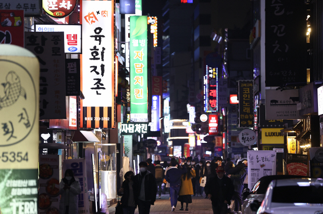 서울시의 ‘셧다운’ 조치 이틀째인 6일 저녁 9시. 영업이 종료된 음식점에서 나온 시민들이 귀가하고 있다./연합뉴스