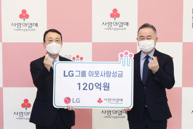 이방수(왼쪽) ㈜LG CSR팀 사장이 8일 서울 중구 사랑의열매 회관에서 예종석 사회복지공동모금회장에게 연말 이웃 사랑 성금 120억 원을 기탁한 뒤 손가락 하트 포즈를 취하고 있다. /사진 제공=LG