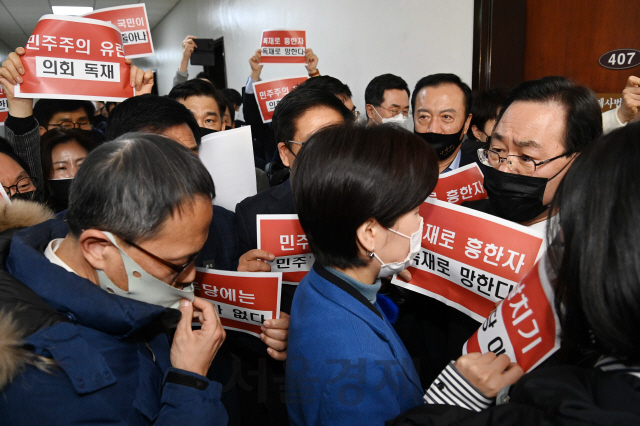 국민의힘 주호영 원내대표와 의원들이 8일 오후 국회 법제사법위원회 전체회의 회의실로 들어가는 더불어민주당 백혜련, 박주민 의원을 향해 피켓을 들고 항의하고 있다./권욱기자 2020.12.08